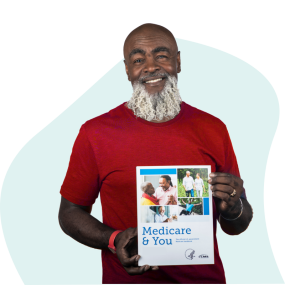 early 60's African American man with beard wearing a red t-shirt and holding a Medicare & You booklet