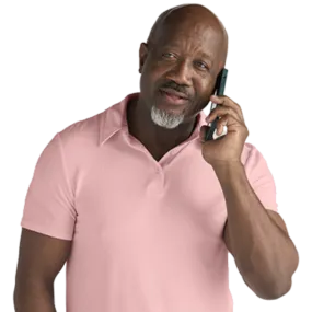 Man in a pink shirt talking on the phone