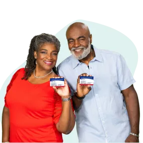 African American couple smiling and holding Medicare cards