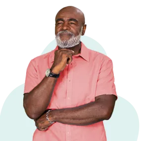 African American man with light red shirt standing and thinking with a smile on his face