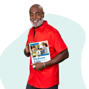 African American man walking, smiling, and holding a copy of the Medicare & You Handbook