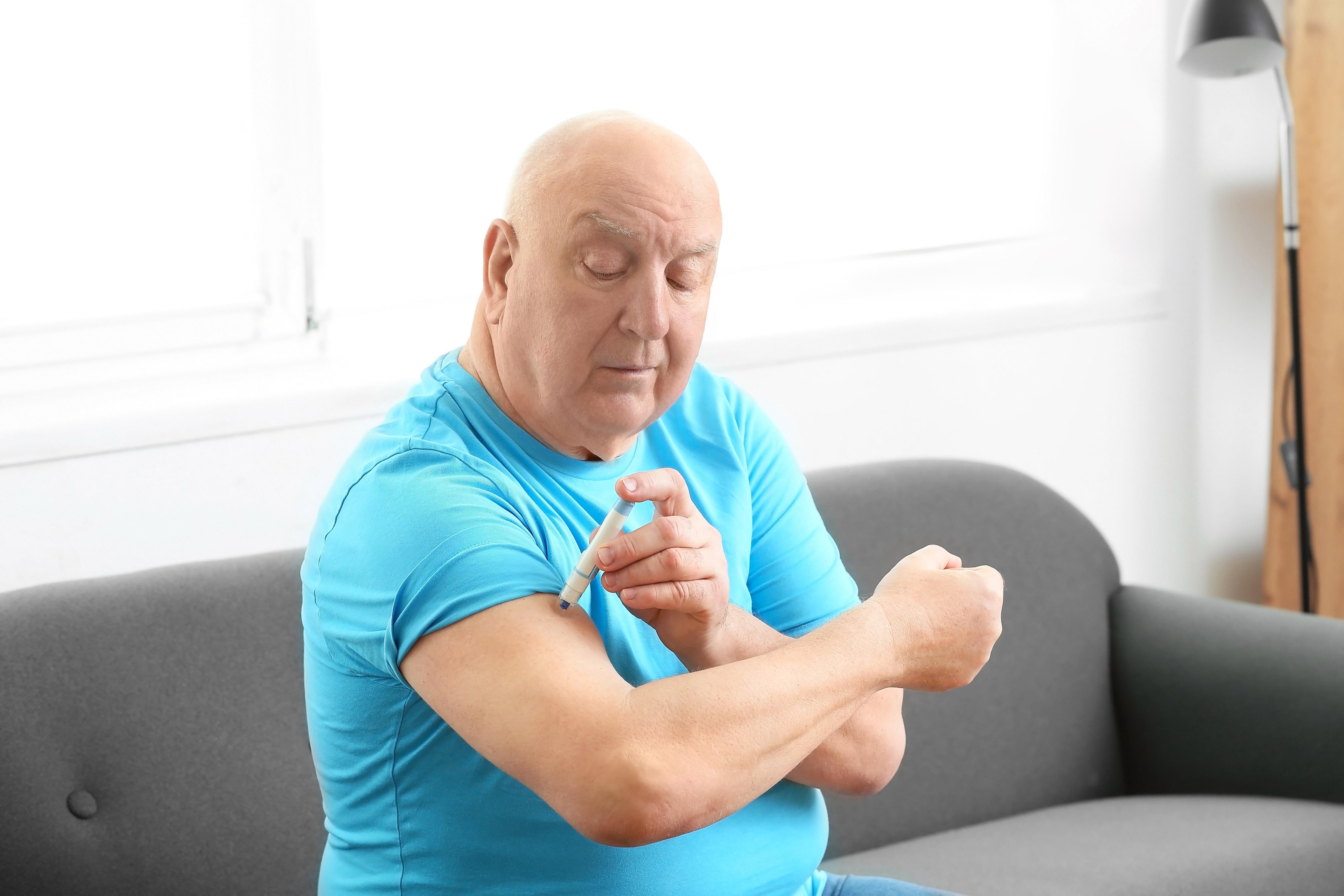 Man in blue shirt using GLP-1 injection
