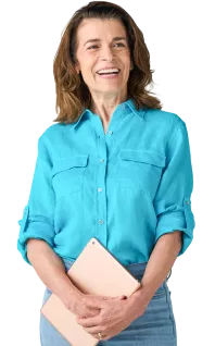 smiling white woman in a blue shirt and jeans holding a tablet