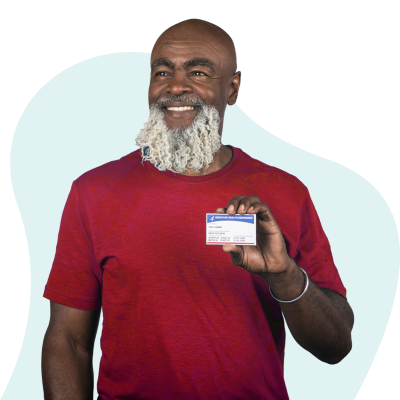 early 60's African American man with beard wearing red t-shirt and holding a sample Medicare card